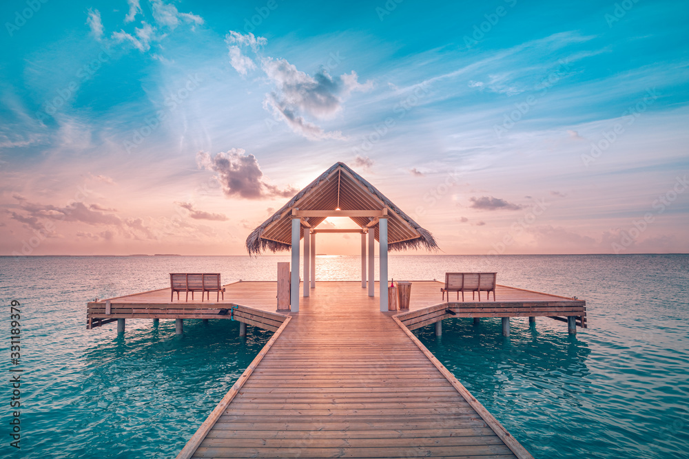 Amazing sunset landscape. Picturesque summer sunset in Maldives. Luxury resort villas seascape with soft led lights under colorful sky. Dream sunset over tropical sea, fantastic nature scenery - obrazy, fototapety, plakaty 