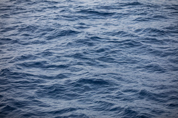 Wall Mural - Background texture of a calm deep blue ocean with ripples on the surface of the sea water