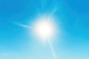 bright sun flares in the clear blue sky. star in space. nature background. energy and power