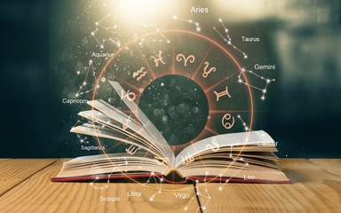 open book on old wooden table with astrology illustration