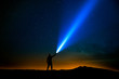 Man with flashlight pointed at the starry sky