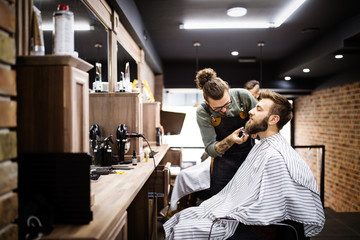 Client during beard and moustache grooming in barber shop