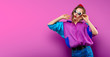 © LoopAll - Cool teenager. Fashionable DJ girl in colorful trendy jacket and vintage retro sunglasses enjoys style of 80s � 90s vibes. Teenager Girl at disco party. Young fashion model on pink color background.