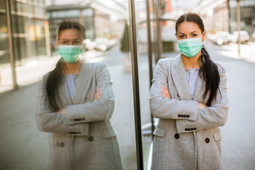 Pretty young woman with protective facial mask on the street