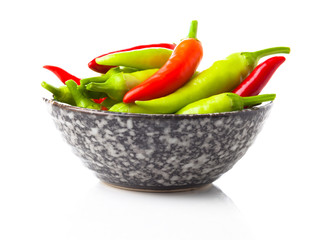 Wall Mural - red and green hot peppers in a cup, on a white background