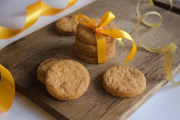 Wall Mural - Parmesan cookies with yellow ribbon on wooden background with fir and garland