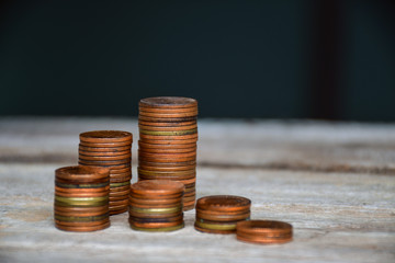 The coin is set into a pile on wood and blurred background. content about finance. Copy space background