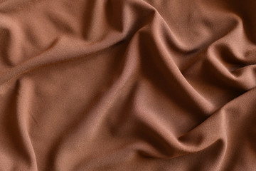 Soft light brown folded fabric for background.