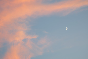 beautiful colorful clouds in the sky with a crescent moon