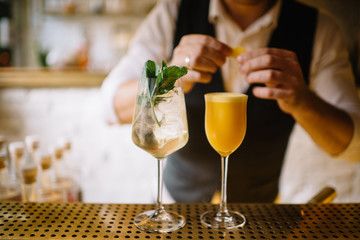 barmen preparing mint spritz and orange sour cocktails