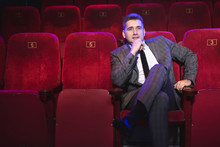 Portrait Of A Young Handsome Man Alone In A Movie Theater In A Business Suit