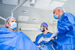 © Vadim - Medical team helping patient. Surgeon with his team performing surgery on a patient, operating theatre room