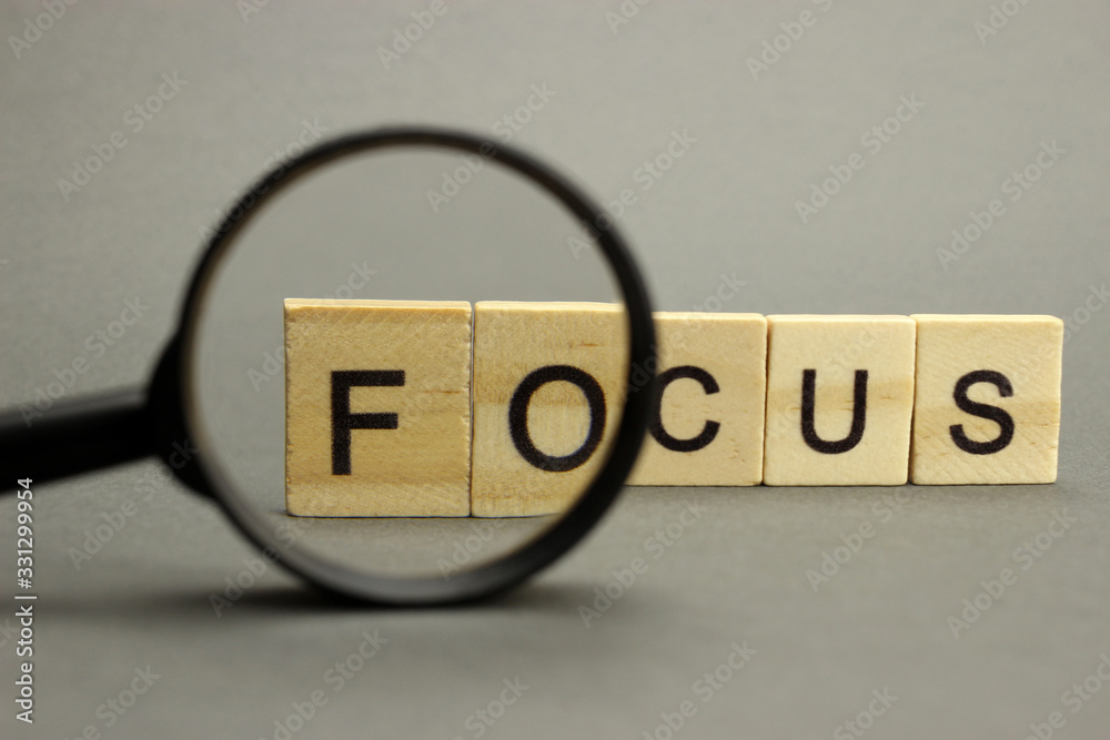 The word focus is made of wooden letters with a magnifying glass. Selective focus - obrazy, fototapety, plakaty 