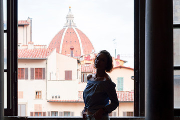 Charming woman stands in the Palazzo Vecchio against the background of the basilica. Tourism and travel concept. Mixed media