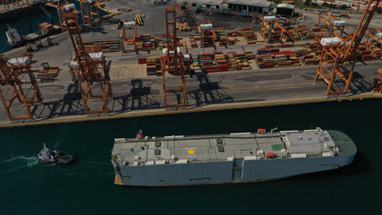 Aerial drone photo of large car carrier ro ro vessel guided by tug boats to dock to Mediterranean port