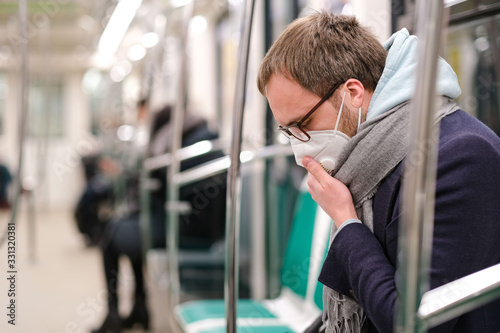 Fotografía Ill man in glasses feeling sick, coughing, wearing respirator N95 mask against t