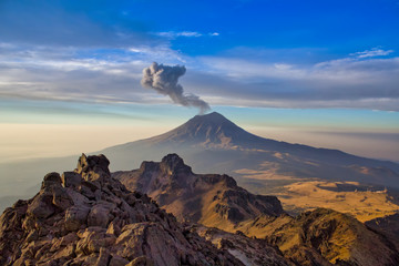 Wall Mural - Popocatepetl volcano in Mexico, Tourist on the peak of high rocks. Sport and active life concept