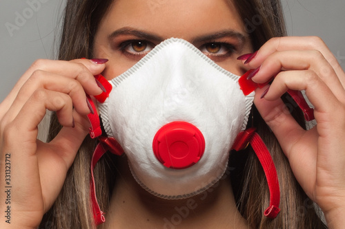 Fotografía Giovane ragazza che indossa, a scopo precauzionale, una mascherina sanitaria ffp