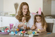 © valeriyakozoriz - happy mother decorate eggs with small dauther for easter.