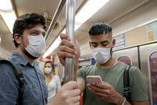 Students and travelers using public transport for commuting. Covid-19 and CoronaVirus concept. People wearing masks on the train.