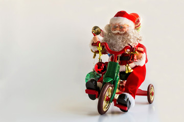 Wall Mural - A happy Santa Claus Toy figure on a bike on white background with copy space