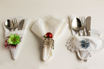 Wall Mural - Handmade lace fabric white color napkin on white surface with metal napkin rings and christmas decoration.