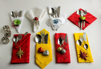 Wall Mural - Christmas cloth and paper napkins folded in various shapes on white surface with napkin rings ,cutlery set and christmas decoration