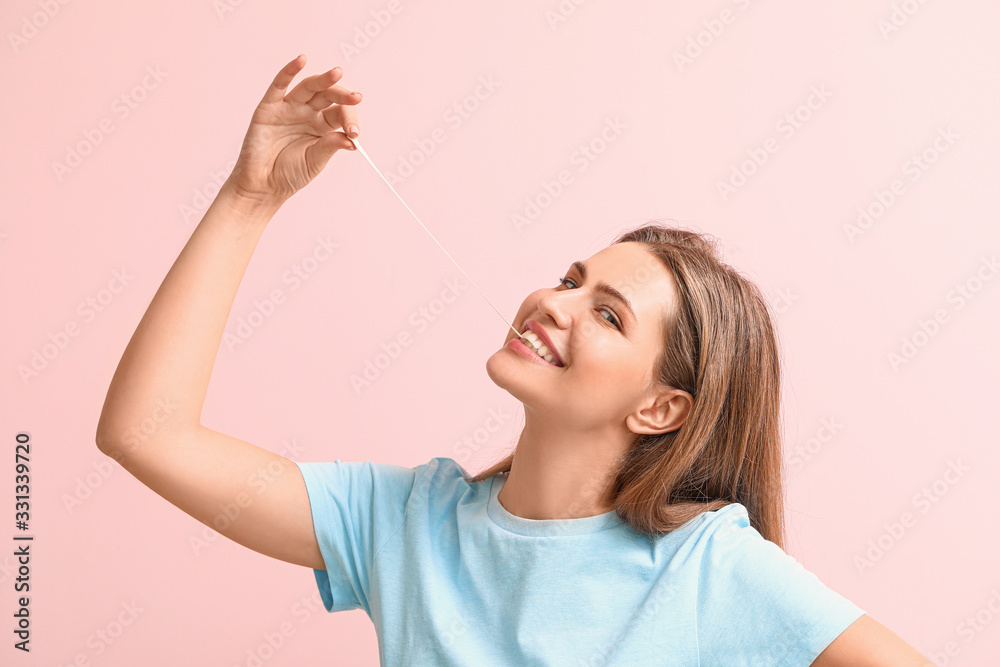 Funny young woman with chewing gum on color background