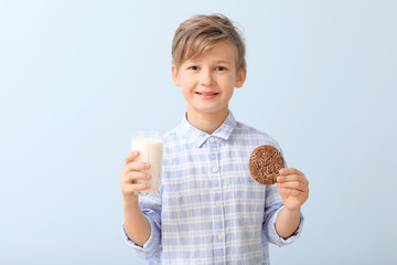 Canvas Print - Little boy with milk and cookie on color background