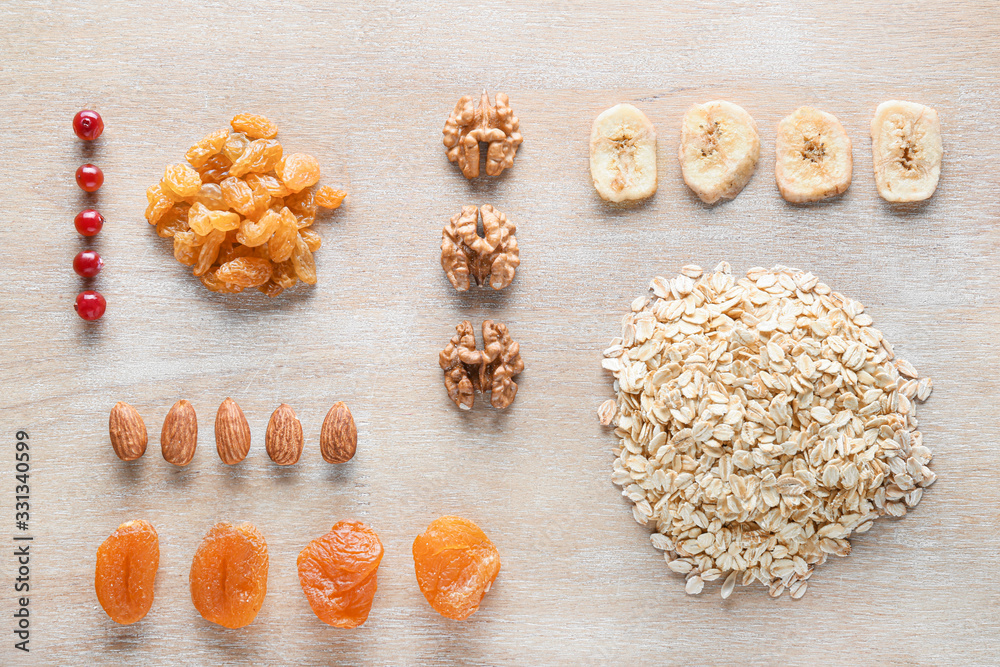 Dry oat grains with fruits and nuts on wooden background - obrazy, fototapety, plakaty 