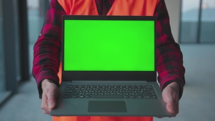 Wall Mural - Close up man hold laptop computer with green screen engineer inside building worker project occupation builder technology mock-up professional male safety device computer slow motion