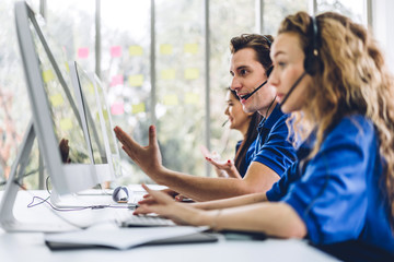 Group of happy call center smiling business operator customer support team phone services agen working and talking with headset on desktop computer at call center