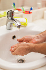 Wall Mural - Man washing hands with soap in bathroom. People and healthcare concept.