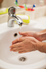 Wall Mural - Man washing hands with soap in bathroom. People and healthcare concept.