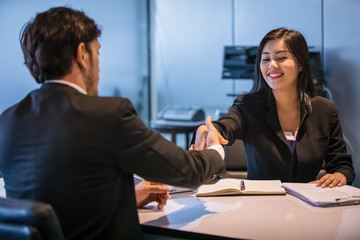 Business people shaking hands and smiling their agreement to sign contract and finishing up a meeting