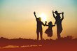 © Janpen - Silhouette of a family comprising a father, mother and two children happy family the sunset.Concept of friendly