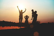 © Janpen - Silhouette of a family comprising a father, mother and two children happy family the sunset.Concept of friendly