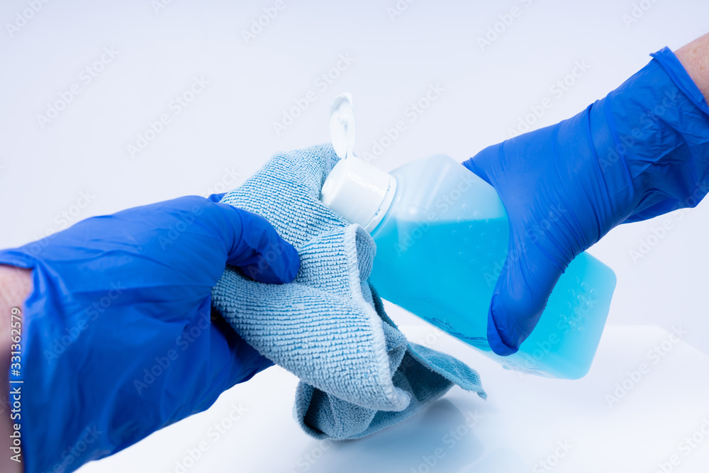 Putting disinfectant onto a cloth for cleaning - obrazy, fototapety, plakaty 