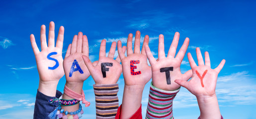 children hands building colorful word safety. blue sky as background