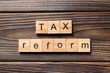 © sosiukin - tax reform word written on wood block. tax reform text on wooden table for your desing, concept