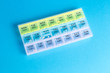 © vfhnb12 - Organizer for medical pills on a blue isolated background close-up. Organization of taking pills of the day.