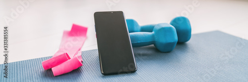 Cuadros en Lienzo Fitness at home online workout on phone app for training inside with dumbbell weights and resistance bands banner background