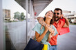 © NDABCREATIVITY - Young attractive happy couple with shopping bags outdoors