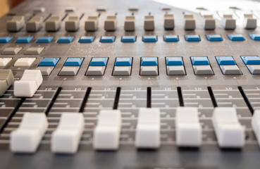 Sound mixer control panel with sliders and buttons closeup. Selective focus.