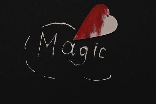 an undecorated red wooden heart and the inscription magic