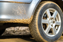Close Up Of Dirty Car Wheel With Rubber Tire Covered With Yellow Mud.