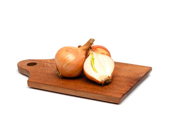 fresh bulbs of onion on a wooden cutting board on a white background