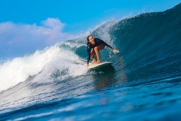 Female surfer on a blue wave