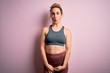 © Krakenimages.com - Young beautiful blonde sportswoman doing sport wearing sportswear over pink background making fish face with lips, crazy and comical gesture. Funny expression.
