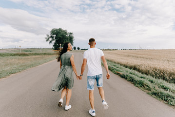 Wall Mural - Romantic young couple sharing a special moment while on a road trip.Man driving car with girlfriend.Sexy girl laying on car and kissing her boyfriend,cool outfit,having fun,sunny,man woman together